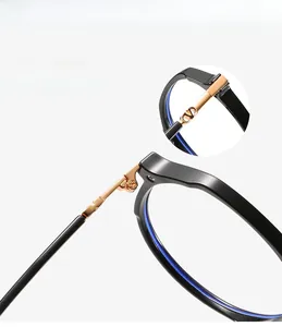 Macro shot of durable gold metal hinge and V logo detail on TR90 black eyeglass frames