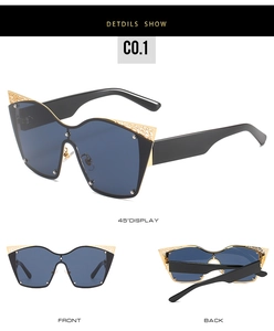 Detail of fashion cat eye sunglasses with golden filigree hollow carving on black frame
