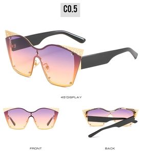 Detail view showing oversized cat-eye sunglasses with purple gradient lenses and gold trim