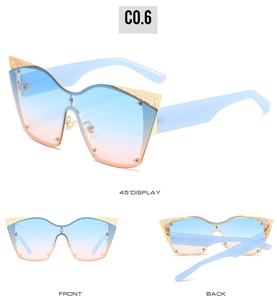 Detail view of cat eye sunglasses with blue-orange gradient lenses and gold lace frame