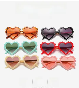 Flat lay of heart-shaped scalloped sunglasses for kids in six vibrant colors