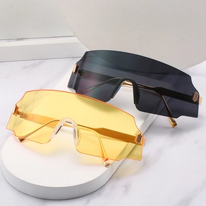 Oversized rimless cycling sunglasses with gold metal temples on marble surface