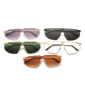 Flat lay of oversized geometric sunglasses set with colorful gradient lenses and gold bridge