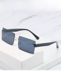 Close-up of modern square frameless sunglasses with blue lenses and gold metal bridge