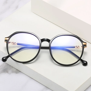 Fashionable black TR90 alloy eyeglasses with large frames and golden V logo on white marble