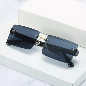 Fashionable square rimless sunglasses with grey lenses and gold metal bridge details