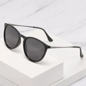 Classic polarized sunglasses with black frame and slim metal temples on white marble