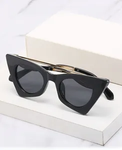 Détail de lunettes œil de chat avec monture noire brillante et branches dorées fines