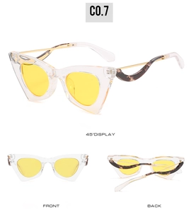 Détail de lunettes de soleil œil de chat monture transparente verres jaunes et branches écaille