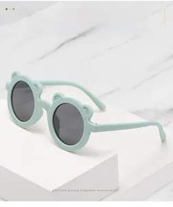 Detail of mint green bear-ear sunglasses for kids with matte texture and dark lenses