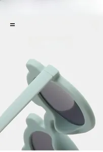 Detail of mint green bear ear sunglasses showing flexible frame and matte texture