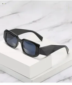 Detail of black square sunglasses with wide temples on white marble display