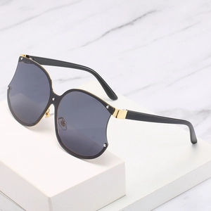 Lunettes de soleil oversize forme pomme avec verres foncés et détails en métal doré chic