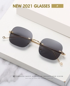 Detail of rimless square computer safety glasses with gold metal temples on marble