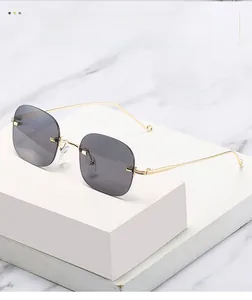 Detailed view of rimless square sunglasses with grey lenses and gold metal frames