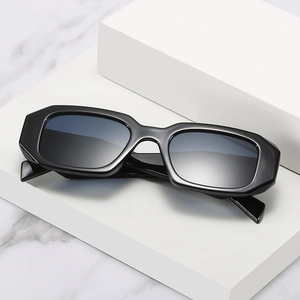 Retro thick rectangular sunglasses with black frame and dark grey lenses on white platform