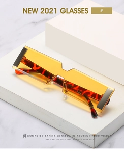 Detail of orange rimless rectangular lenses with tortoiseshell temples and metal hinges