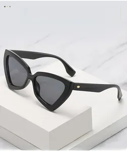 Detail of black cat-eye sunglasses with gold hexagon temple decor on marble