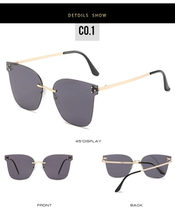 Detail view of rimless sunglasses with grey lenses and gold metal temples