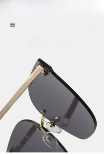 Detail of gold metal hinges and purple gradient lenses on rimless oversized sunglasses