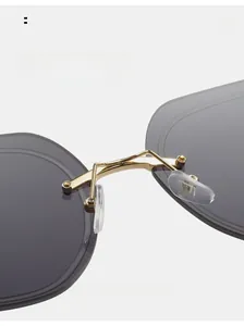 Detail of square sunglasses featuring golden metal bridge and soft silicone nose pads