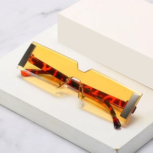 Rectangle rimless sunglasses with amber lenses and tortoise temples on marble stone