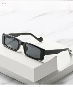 Detail der schwarzen rechteckigen Sonnenbrille mit breitem Rahmen und Kugelenden am Bügel