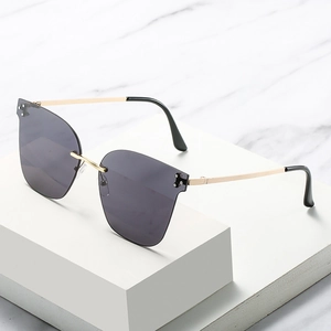 Chic rimless gradient sunglasses with gold metal frame on white geometric display