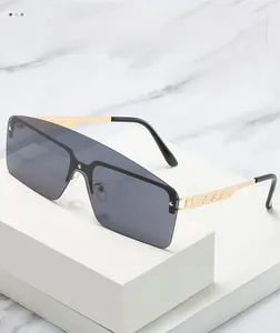 Detail of gold metal temples with hollow geometric patterns on oversized shield sunglasses