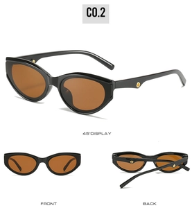 Detail view of cat eye sunglasses in black frame with gold metal accents and brown lenses