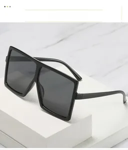 Details einer übergroßen quadratischen Sonnenbrille mit schwarzem Rahmen auf Marmor