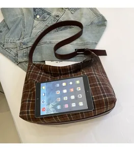 Brown plaid shoulder bag showing large interior capacity with a tablet for size reference