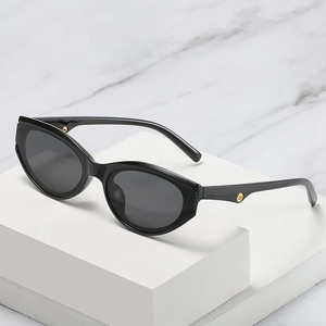 Chic black cat eye sunglasses with golden circular accents on a minimalist marble background