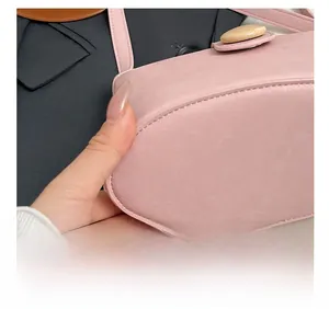 Detailed close-up of pink soft leather bag bottom showing precise stitching and oval wooden buckle