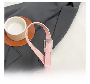 Detailed close-up of adjustable pink leather shoulder strap with silver metal buckle