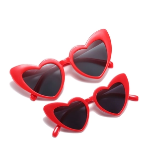 Set of two red heart-shaped cat-eye sunglasses for mother and child on white background