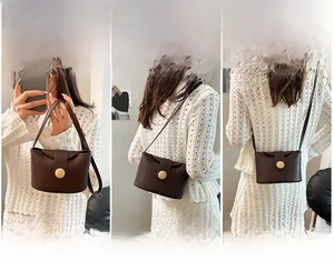 Deep brown leather handbag detail showing handheld, shoulder and crossbody carrying options