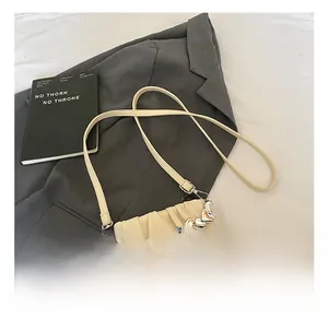 Detail of cream pleated handbag with large pearl handle and silver heart charms