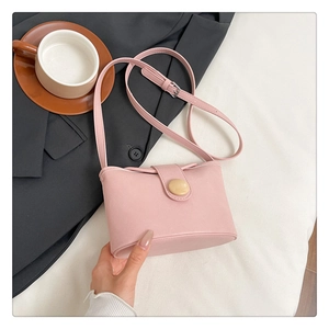 Pink soft leather crossbody bag with wooden buckle and adjustable strap in office setting