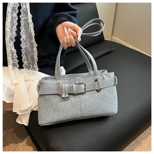Detail of light grey textured denim bag featuring silver metal buckle and strap accents