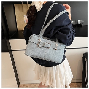 Close-up of light blue denim shoulder bag featuring silver buckle and woven texture