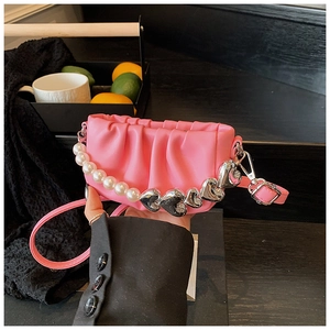 Detailed close-up of pink pleated cloud bag featuring large pearls and silver heart charms