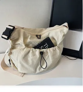 Close-up of cream canvas crossbody bag featuring a functional front drawstring pocket