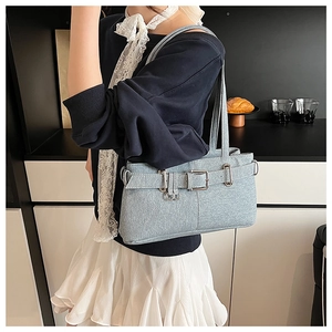 Detail of light blue denim texture shoulder bag with decorative vintage metal buckle