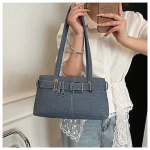 Detail of vintage blue denim bag featuring silver metal buckle and ring accents