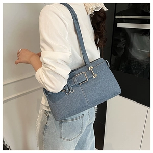 Blue denim crossbody bag with retro belt buckle shown on shoulder for size and fit