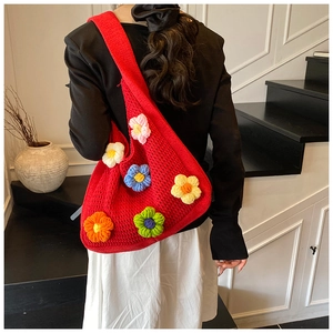 Détail du sac tricoté rouge avec fleurs colorées en 3D faites main et texture de maille
