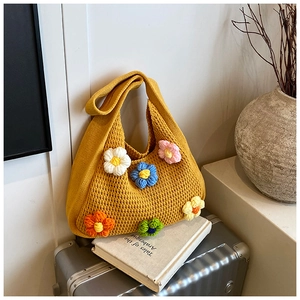 Détail du sac à bandoulière en tricot jaune avec des marguerites colorées en 3D au crochet