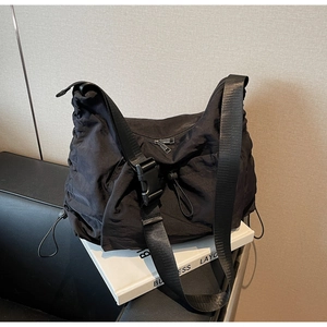 Detail of black nylon crossbody bag with adjustable wide strap and industrial buckle