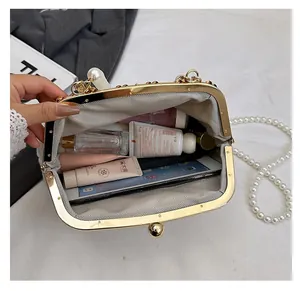 Vue détaillée de la pochette à perles crème spacieuse contenant maquillage et mobile
